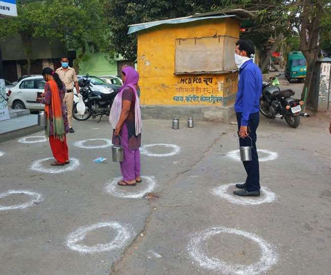 Somewhere in India, people queue up to buy milk with physical distancing.