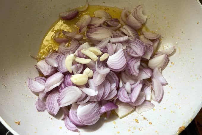 Heat 4 tbsp ghee in a karahi/pan. Once the ghee is hot, add onion and garlic and fry until onion turns translucent.